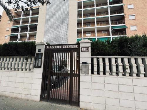 a gate in front of a building with a building at Acogedor apartamento en Playa San Juan in Alicante
