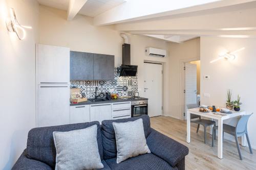 ein Wohnzimmer mit einem blauen Sofa und einer Küche in der Unterkunft Maison Cecile in Verbania