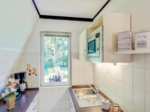 a small kitchen with a sink and a window at A beautiful wooden villa for 12 people in Neubukow