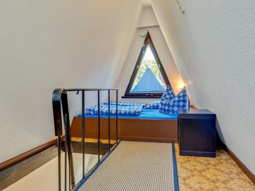 a small attic room with a bed and a window at A beautiful wooden villa for 12 people in Neubukow