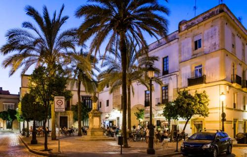 a street with palm trees in front of a building at Porvera - Jerez 6 in Jerez de la Frontera
