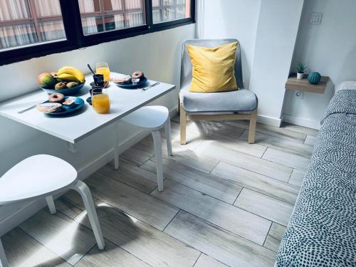 einen Tisch mit einer Schale Obst und zwei Gläsern Orangensaft in der Unterkunft Coqueto apartamento a 50 metros de la playa in Las Palmas de Gran Canaria