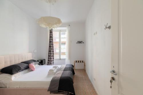 ein Schlafzimmer mit einem Bett in einem Zimmer mit weißen Wänden in der Unterkunft COLOSSEO con il CUORE in Rom