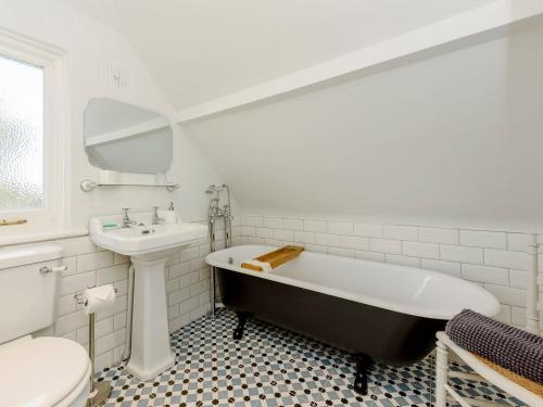 a bathroom with a tub and a sink and a toilet at The Jays in Selsey