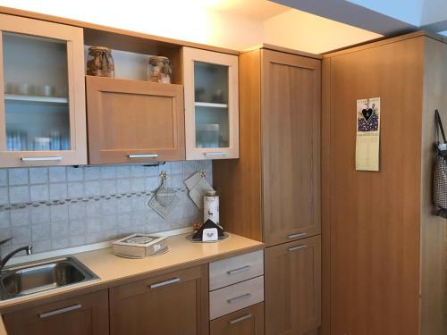 a kitchen with wooden cabinets and a sink at La Casa Shabby in Marilleva