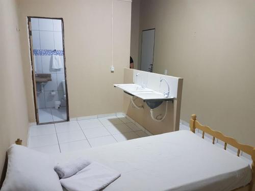 a bathroom with two beds and a sink and a mirror at Residencial Candelária in Natal