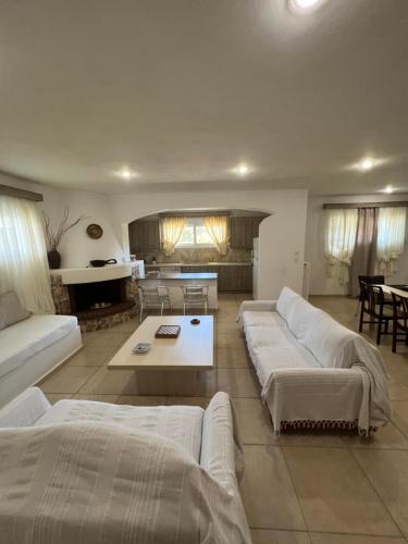 a living room with two white couches and a table at Apartment in Salamina with Garden & Sea view in Selínia