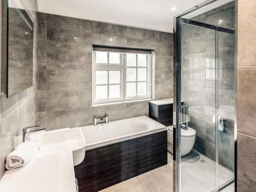 een badkamer met een bad en een toilet bij Drovers in Lanteglos