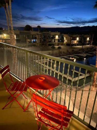 una mesa roja y 2 sillas en el balcón en Private Oasis Condo with River views across from Laughlin en Bullhead City