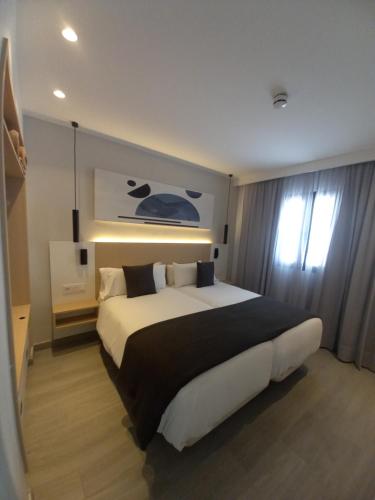 1 dormitorio con 1 cama grande en una habitación de hotel en Apartamentos Marivista, en Playa del Inglés