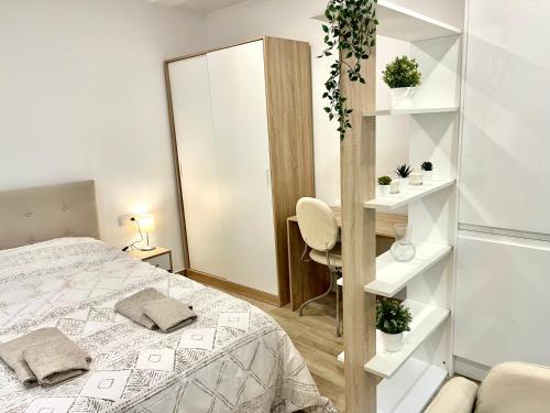 1 dormitorio con cama, silla y espejo en Hospedaje24 - 1, en Manresa
