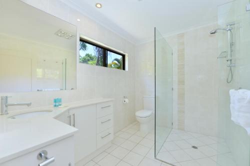 a bathroom with a shower and a sink and a toilet at Sea La Villa Port Douglas in Port Douglas