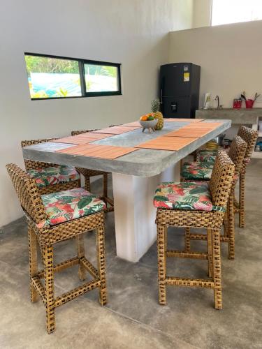 a table with four chairs and a table with a counter at Casa Indica Colombia in Girardot