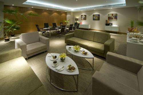a lobby with two tables and chairs and a waiting room at Pullman Kuching in Kuching