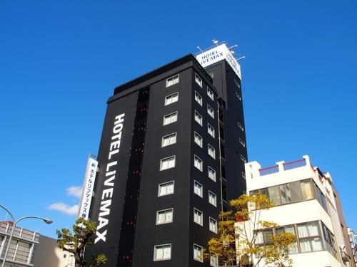 ein schwarzes Gebäude mit weißen Buchstaben drauf in der Unterkunft HOTEL LiVEMAX BUDGET Kobe in Kōbe