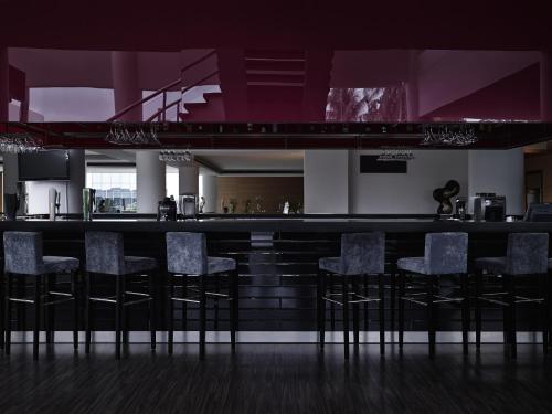 a bar with chairs in a kitchen with purple ceilings at Pullman Kuching in Kuching