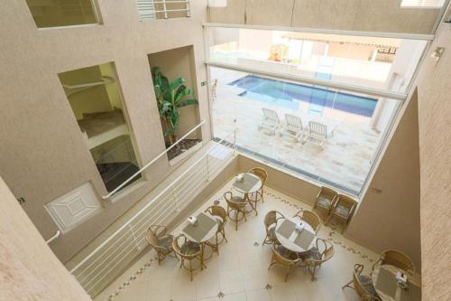 an overhead view of a pool with tables and chairs at Hotel Rosa da Ilha - Pertinho do Mar com piscina in Guarujá