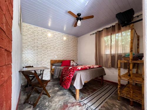1 dormitorio con 1 cama y ventilador de techo en Pousada do Zezé, en Bueno Brandão