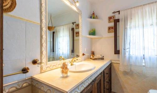 a bathroom with a sink and a large mirror at Casa La Serena in Iznájar