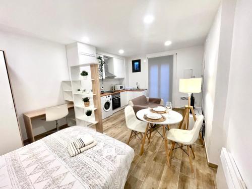 a small room with a bed and a table and chairs at Hospedaje24 - 2 in Manresa