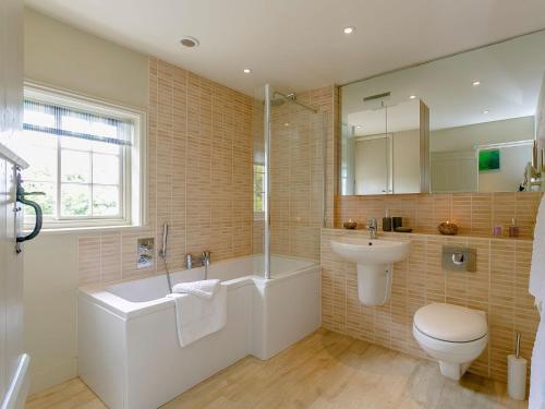 een badkamer met een wastafel, een bad en een toilet bij Rose Cottage in Poynings