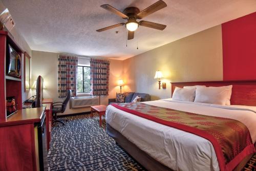 a hotel room with a bed and a ceiling fan at Ramada by Wyndham Oklahoma City Airport North in Oklahoma City