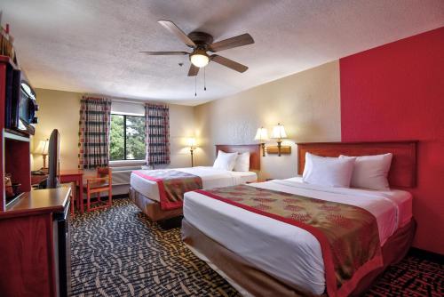 a hotel room with two beds and a flat screen tv at Ramada by Wyndham Oklahoma City Airport North in Oklahoma City