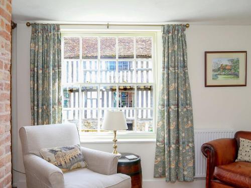 uma sala de estar com uma cadeira e uma janela em Pilgrim Cottage em Hollingbourne