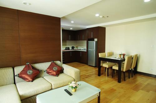 een woonkamer met een bank en een tafel bij The Ninth Place Serviced Residence in Bangna