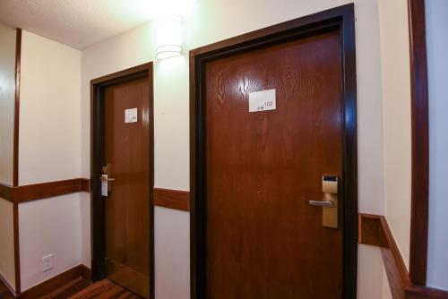 a wooden door in a hallway next to another door at Ramada by Wyndham Oklahoma City Airport North in Oklahoma City