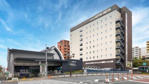 a large building with a hotel in a city at JR-East Hotel Mets Komagome in Tokyo
