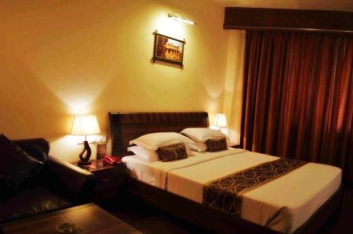 a hotel room with a bed and a couch at Malligi,Hampi in Hospet