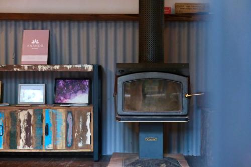 a fireplace with a tv on a blue wall at Ananda Eco House - Eco Rainforest Retreat in Montville