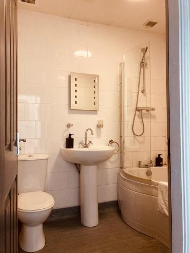 a bathroom with a sink and a toilet and a tub at 'Bloomfield' at stayBOOM in Lancaster