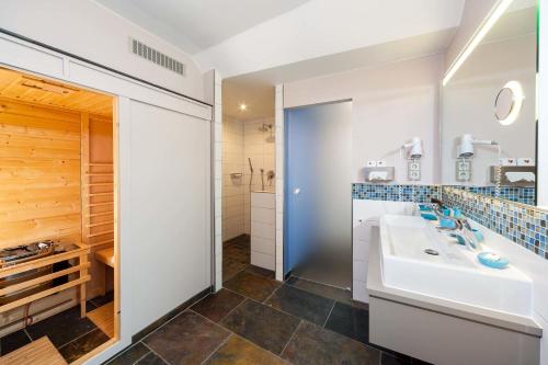 a bathroom with a sink and a mirror at Hotel Halfenstube & Villa Spa 1894 in Senheim