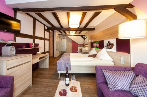 a hotel room with a bed and a couch at Hotel Halfenstube & Villa Spa 1894 in Senheim