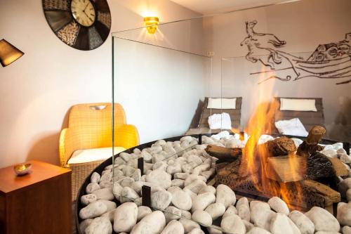 a room with a fireplace and a clock on the wall at Hotel Halfenstube & Villa Spa 1894 in Senheim