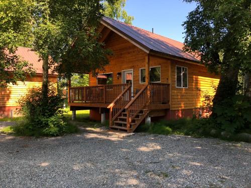 a log cabin with a deck and a porch at Susitna River Lodging, Backwoods Cabins in Talkeetna