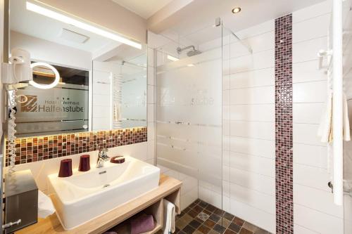 a bathroom with a sink and a glass shower at Hotel Halfenstube & Villa Spa 1894 in Senheim