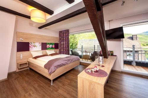 1 dormitorio con 1 cama grande y balcón en Hotel Halfenstube & Villa Spa 1894, en Senheim