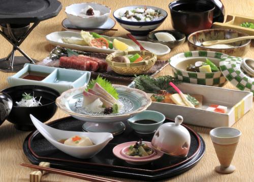 a table topped with bowls filled with food at Kuju Kogen Cottage in Taketa