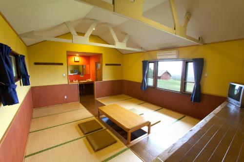 a room with a table and a tv in it at Kuju Kogen Cottage in Taketa