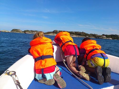 four people in life jackets on a boat in the water at Skottevik Feriesenter in Skottevik