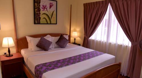 a bedroom with a large bed with a window at D'Vista Residenz in Lotus Desaru Beach Resort in Desaru
