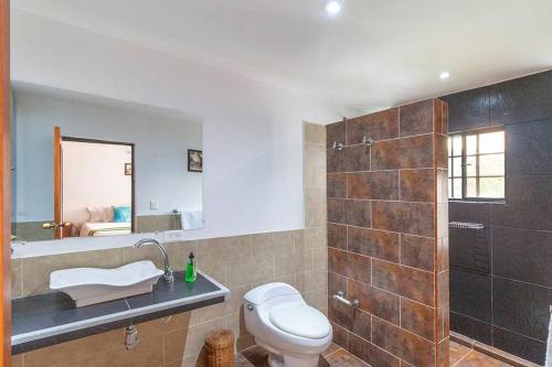 y baño con aseo, lavabo y espejo. en Amazing Finca House Private Swimming Pool & Air Conditioner, en Melgar