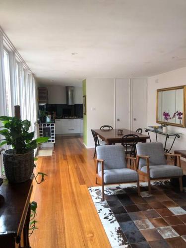 a living room with a table and chairs and a kitchen at Fountain Villa in Camberwell