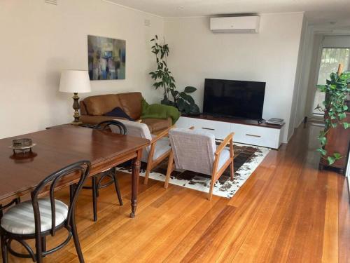 a living room with a table and a couch at Fountain Villa in Camberwell