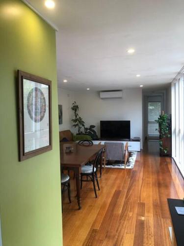 a living room with a dining table and a television at Fountain Villa in Camberwell