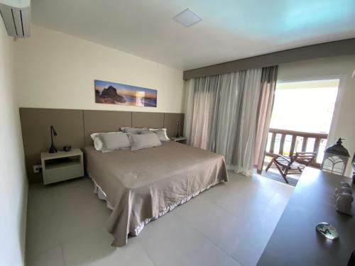 布希奧斯的住宿－Buzios Beach Resort Super Luxo Residencial 2501 e 2502，一间带大床的卧室和一个阳台