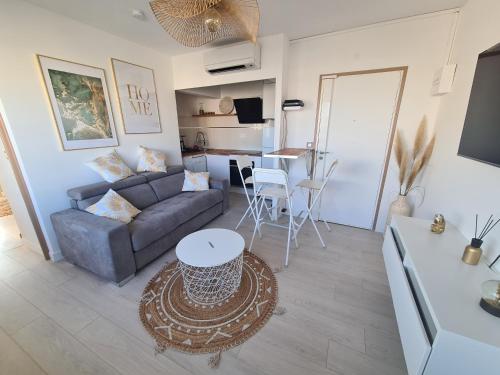 uma sala de estar com um sofá e uma mesa em Appartement lumineux avec vue sur mer em La Grande-Motte